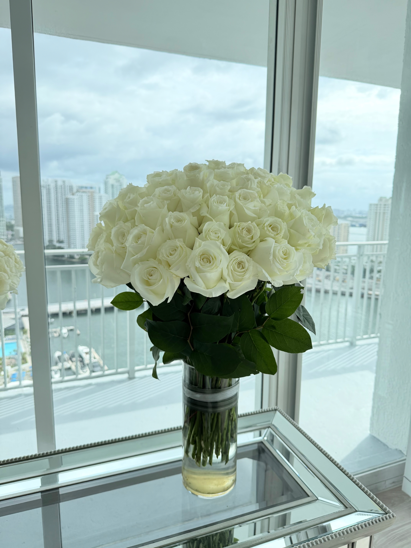 80 white roses arrangement with Brickell bay view